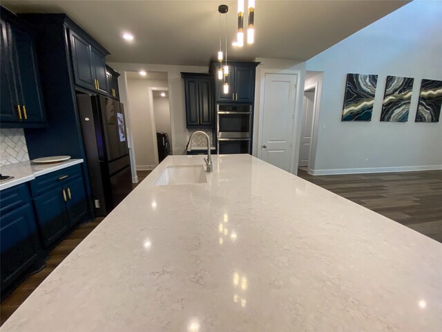 10011 Serenity Grove Dr, Missouri City, TX 77459 - kitchen with stainless steel double oven, black fridge, tasteful backsplash, dark wood-style floors, and light stone countertops