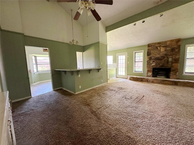 288 Twin Lakes Blvd W, West Columbia, TX 77486 - unfurnished living room with carpet floors, a ceiling fan, plenty of natural light, a fireplace, and high vaulted ceiling