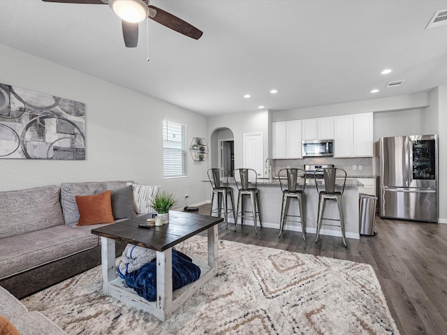 22010 Great Royal Ln, Houston, TX 77073 - living room featuring ceiling fan, dark wood-type flooring, recessed lighting, and arched walkways