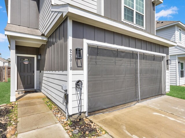 22010 Great Royal Ln, Houston, TX 77073 - doorway to property with an attached garage, board and batten siding, and driveway