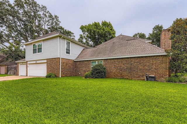 20746 Prince Creek Dr, Katy, TX 77450 - view of home's exterior featuring a lawn, an attached garage, brick siding, and a shingled roof