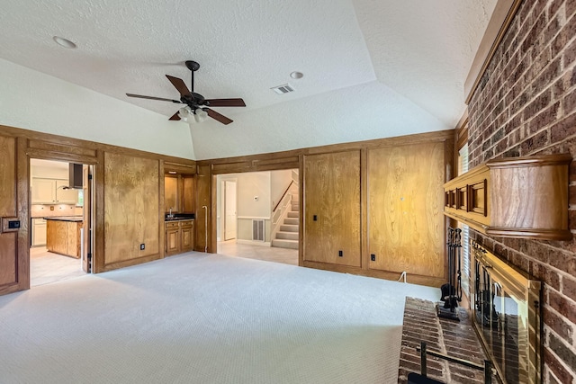20746 Prince Creek Dr, Katy, TX 77450 - unfurnished living room featuring a fireplace, lofted ceiling, ceiling fan, a textured ceiling, and stairs