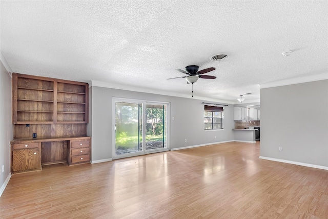 1015 Stevens Ave, Conroe, TX 77301 - unfurnished living room with ceiling fan, light wood-style floors, and a textured ceiling