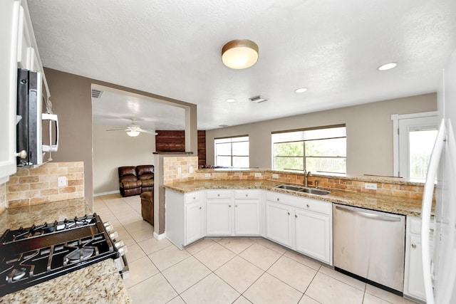 16227 Affirmed Way, Friendswood, TX 77546 - kitchen with stainless steel appliances, backsplash, white cabinetry, light tile patterned floors, and a ceiling fan