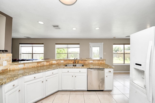 16227 Affirmed Way, Friendswood, TX 77546 - kitchen with stainless steel dishwasher, white refrigerator with ice dispenser, light tile patterned floors, backsplash, and white cabinetry