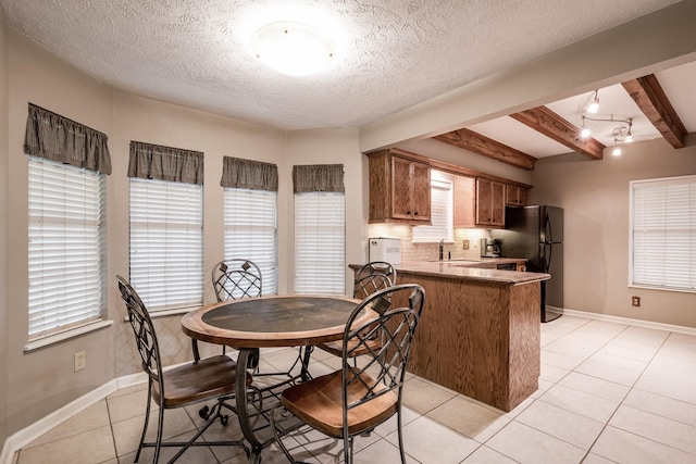 4821 Lawrence Rd, Baytown, TX 77523 - dining space with light tile patterned flooring, beamed ceiling, and a textured ceiling