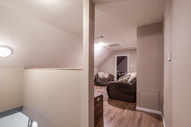 4821 Lawrence Rd, Baytown, TX 77523 - additional living space featuring wood finished floors, vaulted ceiling, and a textured ceiling
