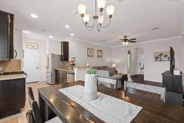13203 Adolpho Dr, Houston, TX 77044 - dining room with arched walkways, a ceiling fan, a chandelier, crown molding, and recessed lighting