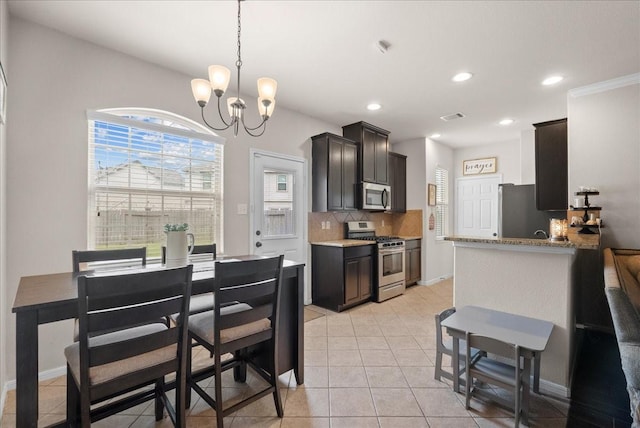 13203 Adolpho Dr, Houston, TX 77044 - kitchen with stainless steel appliances, decorative backsplash, a chandelier, light tile patterned floors, and recessed lighting