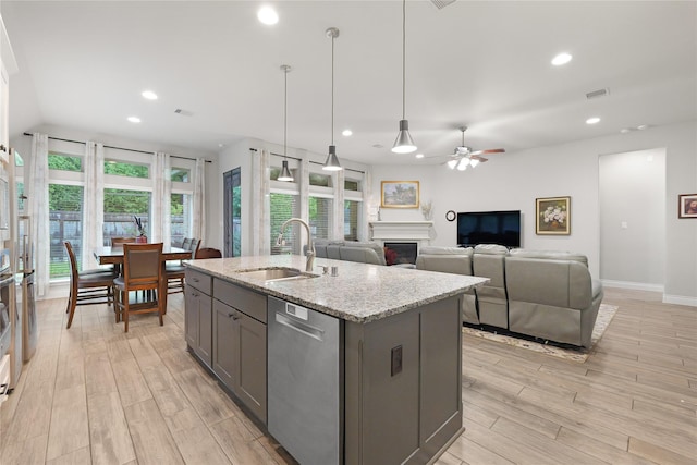 23649 Sage Villa Dr, New Caney, TX 77357 - kitchen featuring dishwasher, gray cabinetry, light wood finished floors, a fireplace, and recessed lighting