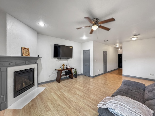 2905 Baer St Unit 6, Houston, TX 77020 - living area featuring a ceiling fan, a fireplace with flush hearth, and light wood-type flooring