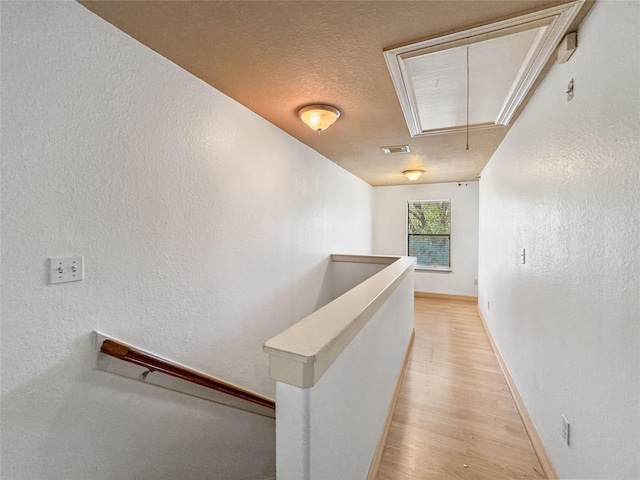 2905 Baer St Unit 6, Houston, TX 77020 - corridor with attic access, an upstairs landing, light wood-type flooring, and a textured wall