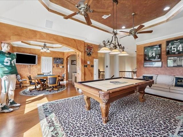2700 Spurlock Rd, Nederland, TX 77627 - playroom featuring a ceiling fan, arched walkways, a raised ceiling, wood finished floors, and crown molding