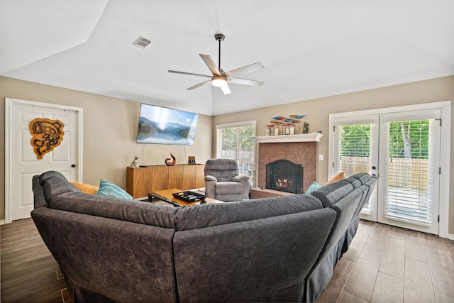 4920 Fm 350 N, Livingston, TX 77351 - living area featuring wood finished floors, lofted ceiling, a ceiling fan, a brick fireplace, and french doors