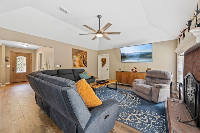 4920 Fm 350 N, Livingston, TX 77351 - living room with wood finished floors, a brick fireplace, vaulted ceiling, and a ceiling fan