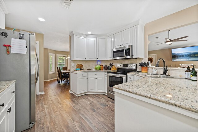 4920 Fm 350 N, Livingston, TX 77351 - kitchen with appliances with stainless steel finishes, light wood-style flooring, decorative backsplash, white cabinetry, and recessed lighting