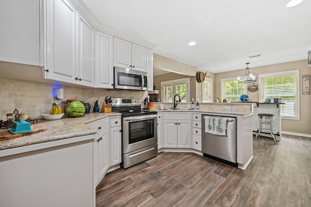 4920 Fm 350 N, Livingston, TX 77351 - kitchen with stainless steel appliances, a peninsula, dark wood-type flooring, white cabinets, and recessed lighting