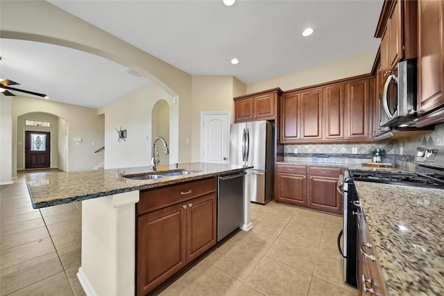 208 Harbor Bend Ln, Dickinson, TX 77539 - kitchen with appliances with stainless steel finishes, light tile patterned floors, arched walkways, an island with sink, and recessed lighting