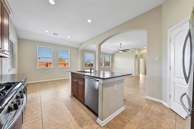 208 Harbor Bend Ln, Dickinson, TX 77539 - kitchen featuring arched walkways, appliances with stainless steel finishes, light tile patterned flooring, ceiling fan, and a kitchen island with sink