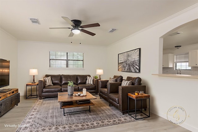 113 N Holmes St, La Porte, TX 77571 - living area featuring ceiling fan, arched walkways, light wood-style flooring, and crown molding