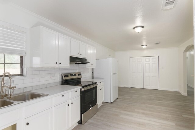 113 N Holmes St, La Porte, TX 77571 - kitchen with stainless steel electric range oven, under cabinet range hood, freestanding refrigerator, tasteful backsplash, and crown molding