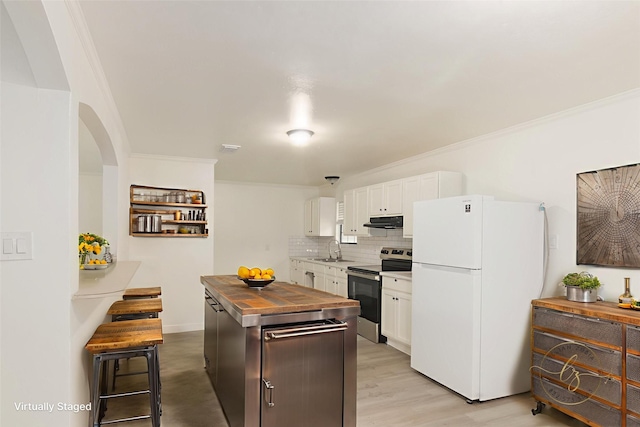 113 N Holmes St, La Porte, TX 77571 - kitchen featuring freestanding refrigerator, electric range, under cabinet range hood, wooden counters, and white cabinetry