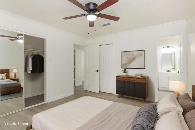 113 N Holmes St, La Porte, TX 77571 - bedroom featuring light wood-style flooring, crown molding, ensuite bathroom, ceiling fan, and two closets