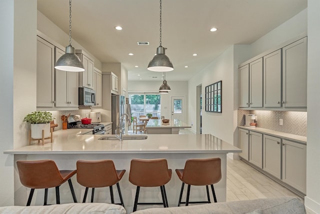 454 Glacier Pass, Montgomery, TX 77316 - kitchen featuring stainless steel appliances, a peninsula, recessed lighting, a kitchen bar, and light countertops