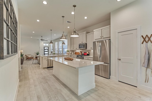 454 Glacier Pass, Montgomery, TX 77316 - kitchen featuring stainless steel appliances, recessed lighting, a peninsula, light wood finished floors, and a kitchen island