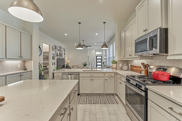 454 Glacier Pass, Montgomery, TX 77316 - kitchen with stainless steel appliances, tasteful backsplash, light stone counters, recessed lighting, and pendant lighting