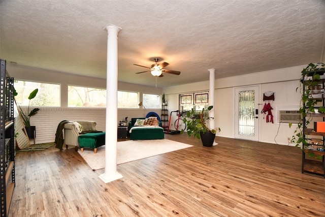 2019 N Thompson St, Conroe, TX 77301 - living area with ornate columns, wood finished floors, ceiling fan, and a textured ceiling