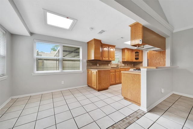 24193 Kelly St, Porter, TX 77365 - kitchen with a peninsula, decorative backsplash, light countertops, and light tile patterned floors