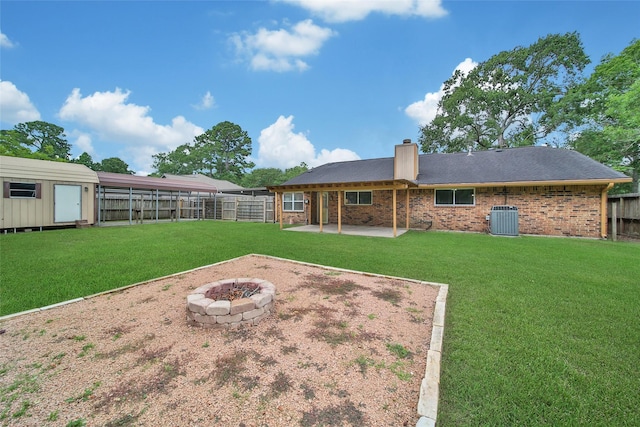 24193 Kelly St, Porter, TX 77365 - rear view of property with a fire pit, a chimney, a patio area, a fenced backyard, and brick siding
