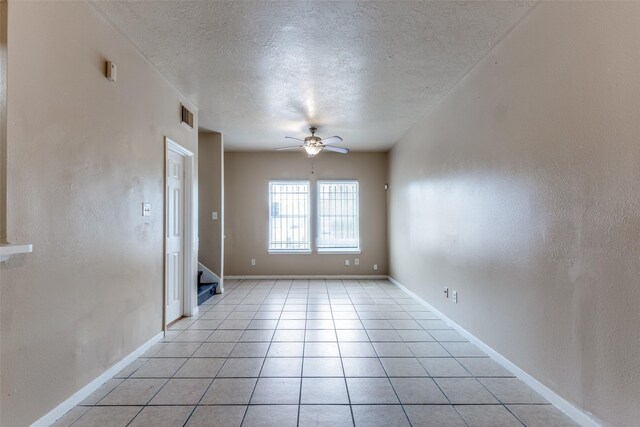 8130 Jutland Rd, Houston, TX 77033 - empty room featuring ceiling fan, a textured ceiling, stairs, and light tile patterned flooring