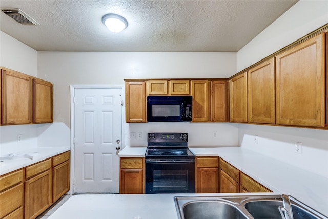 8130 Jutland Rd, Houston, TX 77033 - kitchen featuring black appliances, light countertops, brown cabinetry, and a textured ceiling