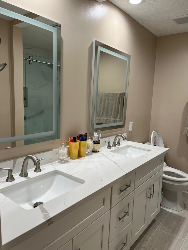 12117 Bob White Dr, Houston, TX 77035 - full bathroom with double vanity, a shower stall, and a textured ceiling
