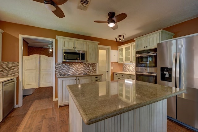 5425 Sandy Creek Ln, Brenham, TX 77833 - kitchen featuring stainless steel appliances, ceiling fan, dark wood-style floors, tasteful backsplash, and glass insert cabinets