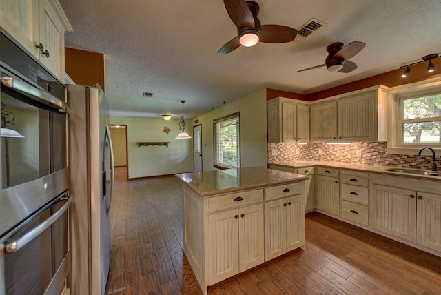 5425 Sandy Creek Ln, Brenham, TX 77833 - kitchen with cream cabinetry, a ceiling fan, decorative backsplash, a textured ceiling, and healthy amount of natural light