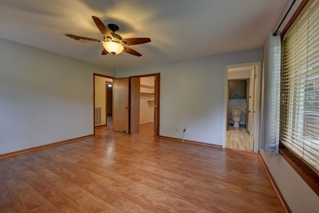 5425 Sandy Creek Ln, Brenham, TX 77833 - unfurnished bedroom with light wood-style floors, ensuite bath, a walk in closet, ceiling fan, and a closet