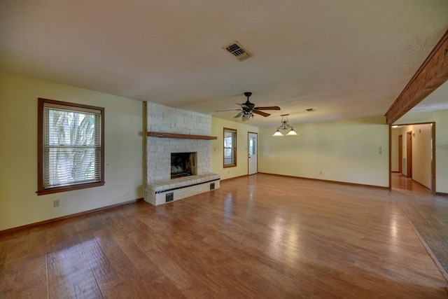 5425 Sandy Creek Ln, Brenham, TX 77833 - unfurnished living room with ceiling fan, wood finished floors, and a stone fireplace