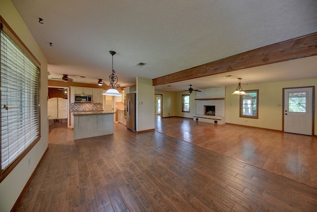 5425 Sandy Creek Ln, Brenham, TX 77833 - unfurnished living room featuring a fireplace, a ceiling fan, and dark wood-style floors