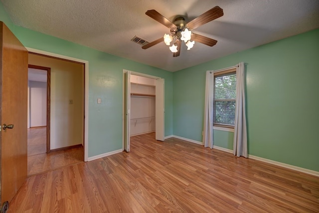 5425 Sandy Creek Ln, Brenham, TX 77833 - unfurnished bedroom featuring light wood finished floors, a closet, a textured ceiling, and a ceiling fan
