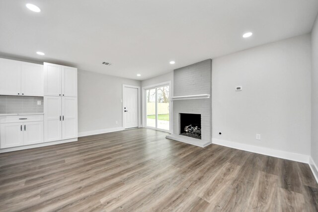 9414 Colleen Rd, Houston, TX 77080 - unfurnished living room featuring recessed lighting, light wood finished floors, and a brick fireplace