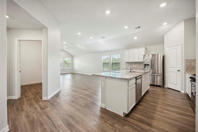 2539 Blazing Star Dr, Brookshire, TX 77423 - kitchen with appliances with stainless steel finishes, vaulted ceiling, white cabinetry, dark wood-style flooring, and backsplash