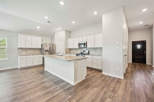 2539 Blazing Star Dr, Brookshire, TX 77423 - kitchen featuring stainless steel appliances, decorative backsplash, an island with sink, wood finished floors, and recessed lighting