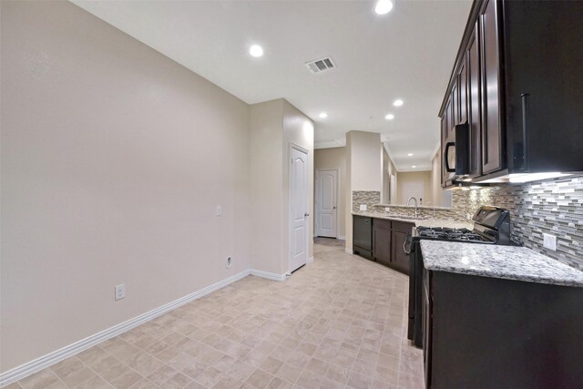 19823 White Pearl Ct, Houston, TX 77073 - kitchen featuring range with gas stovetop, backsplash, black microwave, recessed lighting, and light stone countertops