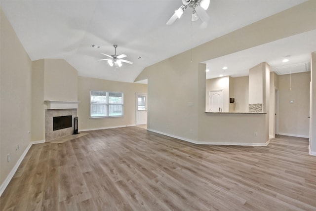19823 White Pearl Ct, Houston, TX 77073 - unfurnished living room with a ceiling fan, attic access, light wood-style floors, lofted ceiling, and a tile fireplace