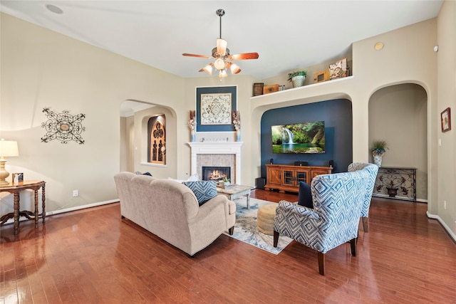 20811 S Amber Willow Trl, Cypress, TX 77433 - living area featuring wood finished floors, ceiling fan, arched walkways, and a tiled fireplace