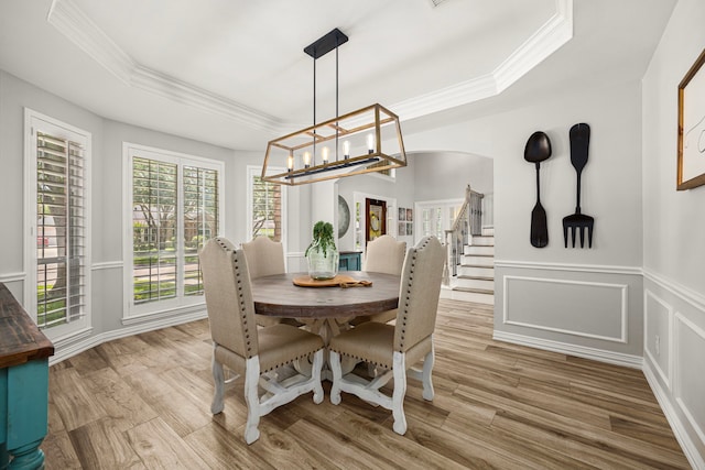 3506 Stanbury Place Ln, Katy, TX 77494 - dining space featuring a tray ceiling, crown molding, wood finished floors, a chandelier, and wainscoting