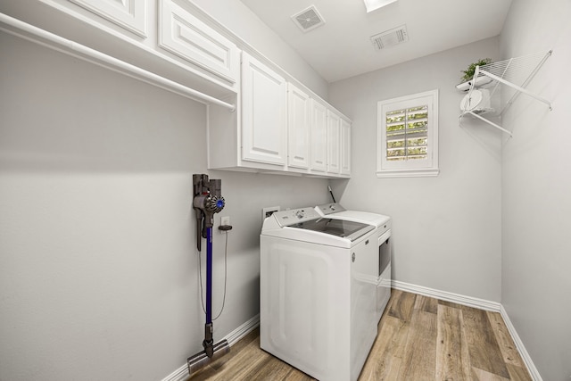 3506 Stanbury Place Ln, Katy, TX 77494 - washroom with washer and clothes dryer, light wood finished floors, and cabinet space